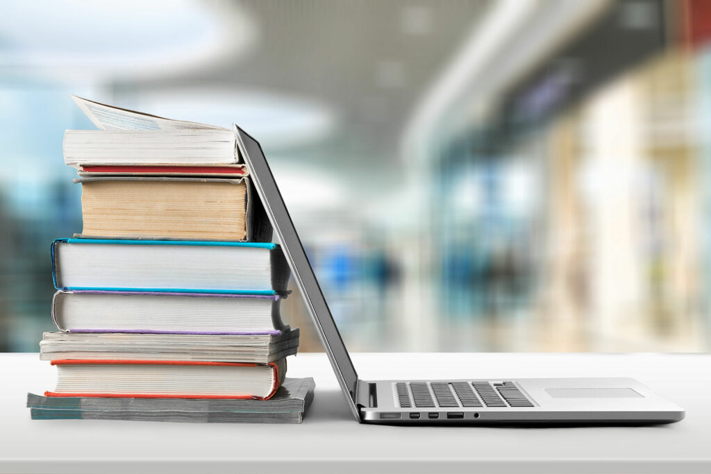 Laptop resting on stack of books